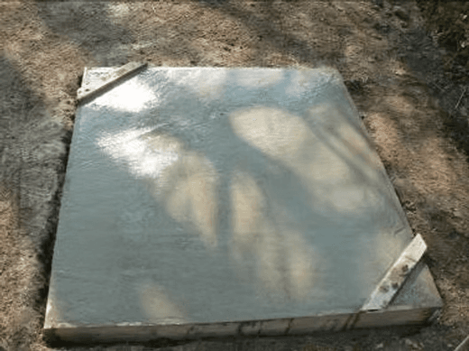 Das frisch gegossene Betonfundament in seiner Holzschalung